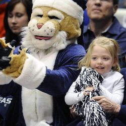 Four-year-old Preslee Nellesen dressed up as a BYU cheerleader and shows her spirit as Cosmo the Cougar came by and sat next to her during the Cougars game against the Prairie View A&M Panthers at the Marriott Center in Provo on Wednesday, Dec. 11, 2013.
