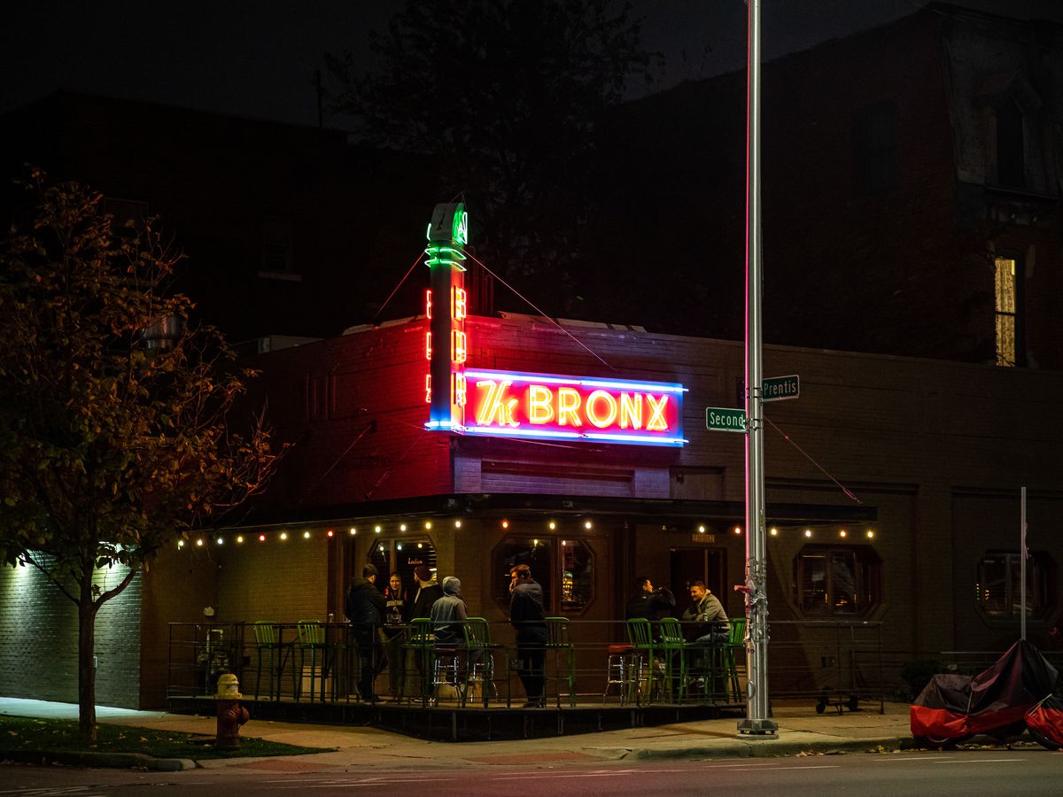 The Bronx shown at night with customers gathered on the smoking patio at the corner.