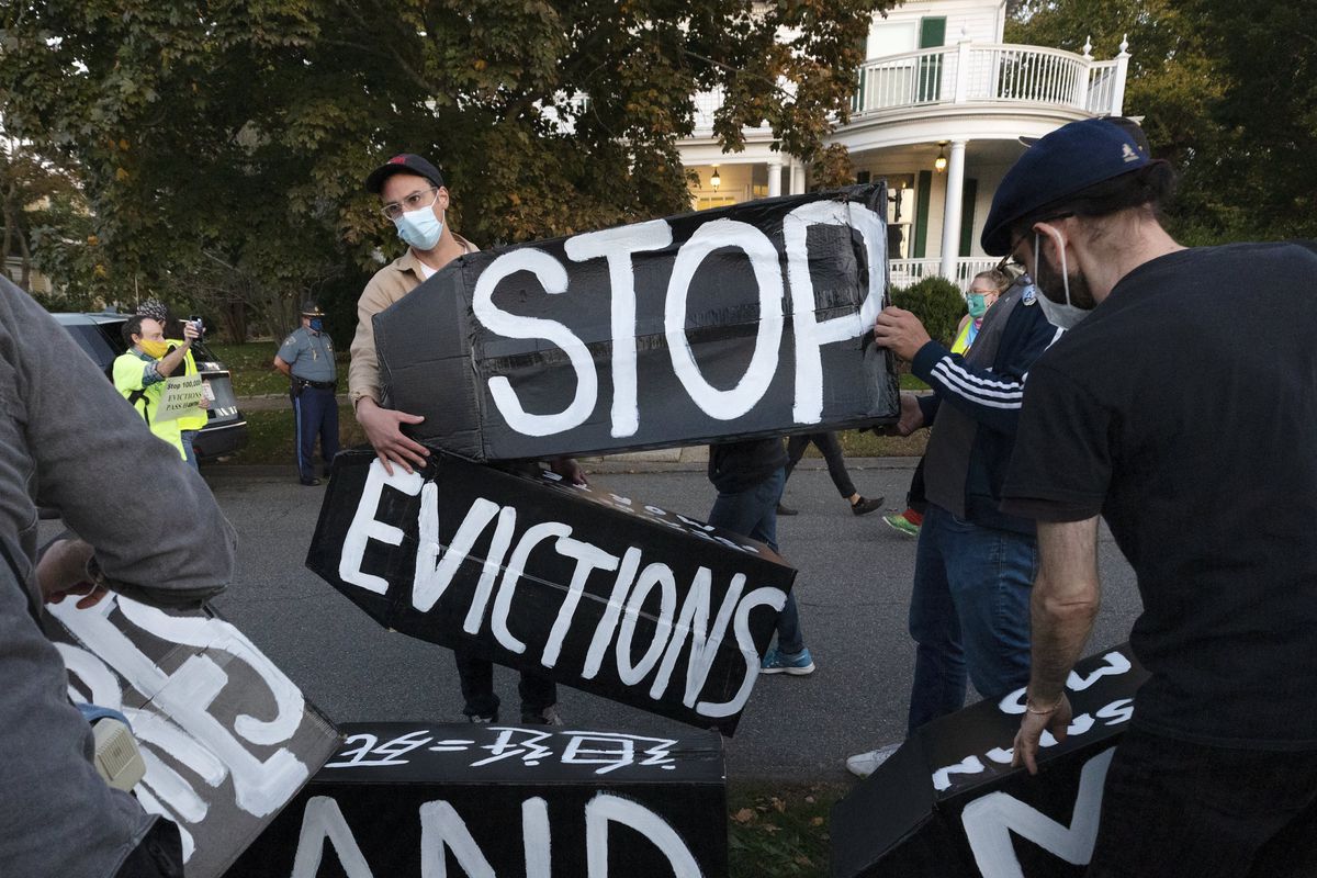 Housing activists hold signs protesting evictions in Massachusetts in October 2020.