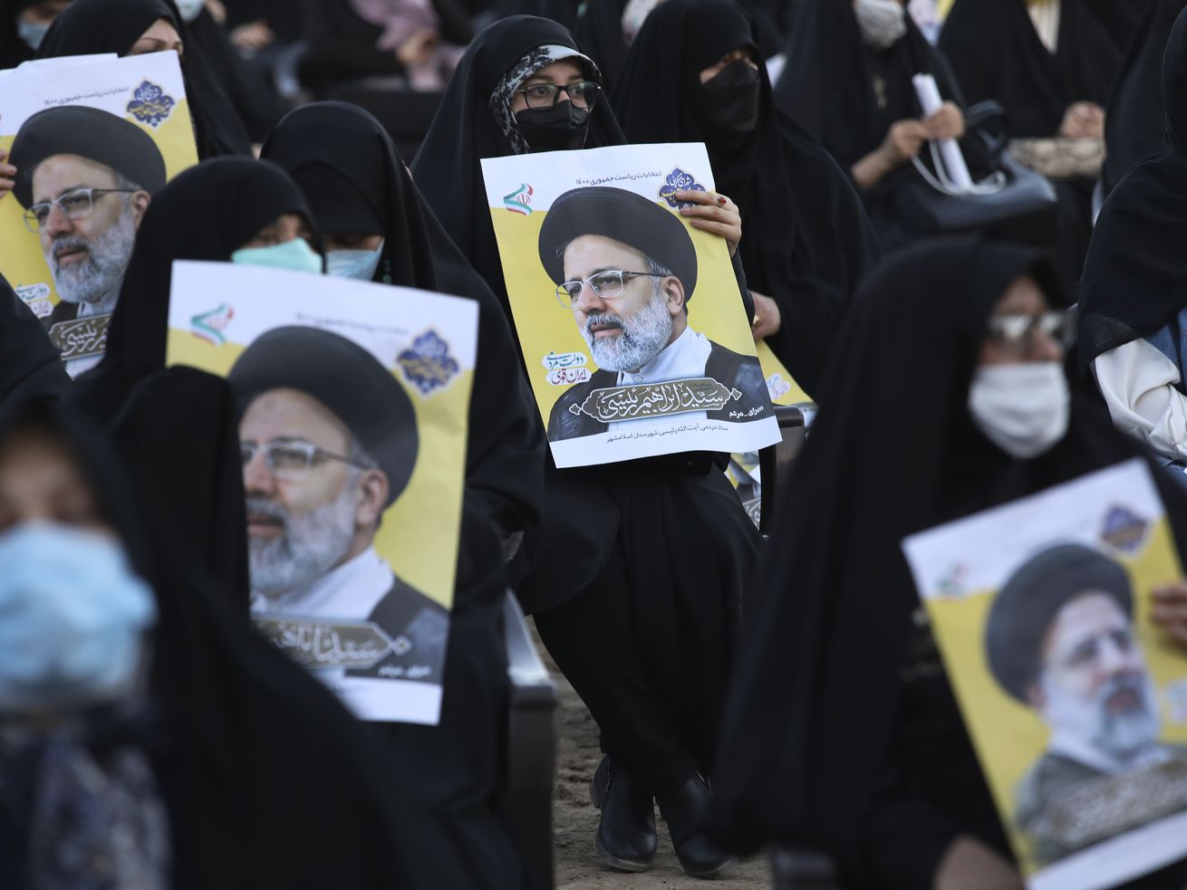 Supporters of the presidential candidate Ebrahim Raisi, currently judiciary chief, hold his posters during a campaign rally in town of Eslamshahr southwest of the capital Tehran, Iran, Sunday, June 6, 2021. Iran will hold presidential elections on June 18 with 7 candidates approved by the Guardian Council. 