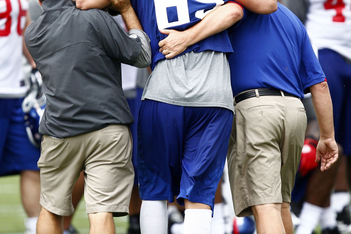 Jul 28, 2012; Albany, NY, USA; New York Giants defensive end Justin Trattou (69) is helped off the field after injuring himself during training camp at University Field at SUNY Albany.  Mandatory Credit: Mark L. Baer-US PRESSWIRE