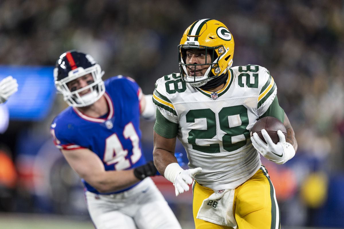 AJ Dillon #28 of the Green Bay Packers runs with the ball during an NFL football game between the New York Giants and the Green Bay Packers at MetLife Stadium on December 11, 2023 in East Rutherford, New Jersey.