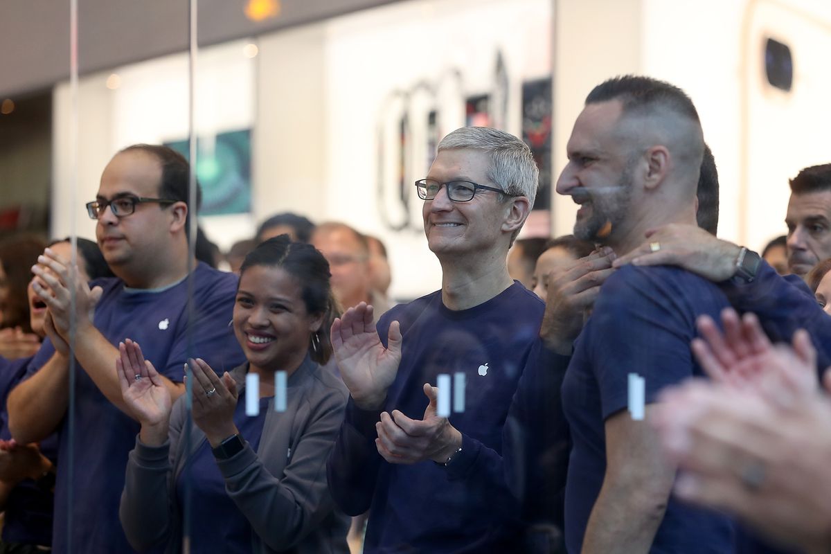 Apple CEO Tim Cook applauds at an Apple Store event