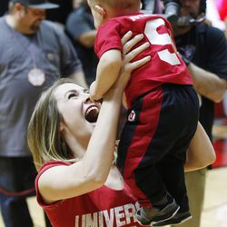 Lindsey Beyer holds her baby Mitchell after he won a baby crawling contest at half during the Utah Washington State game in Salt Lake City Sunday, Feb. 14, 2016. Utah won 88-47.