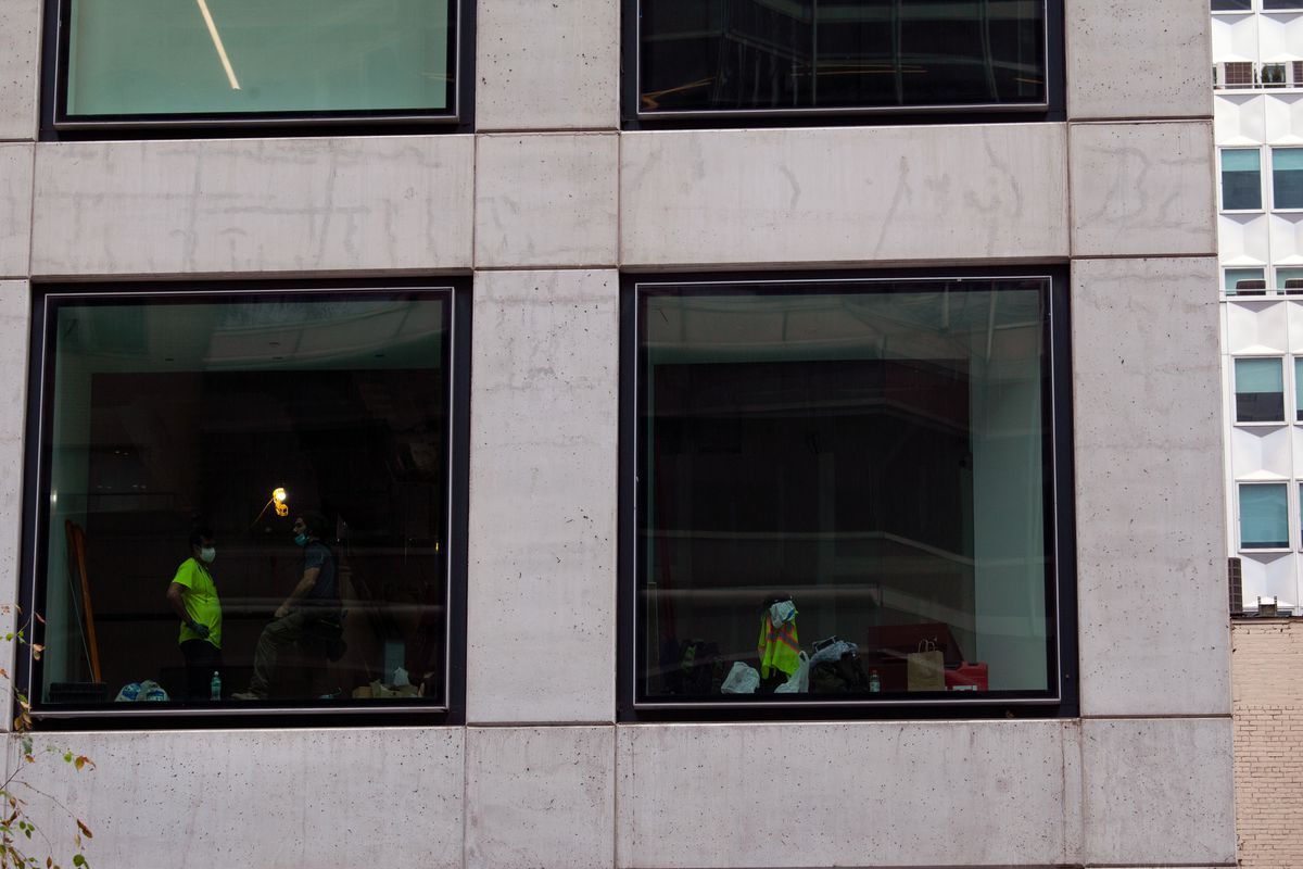 Construction workers speak inside an empty Midtown office, Sept. 1, 2020.