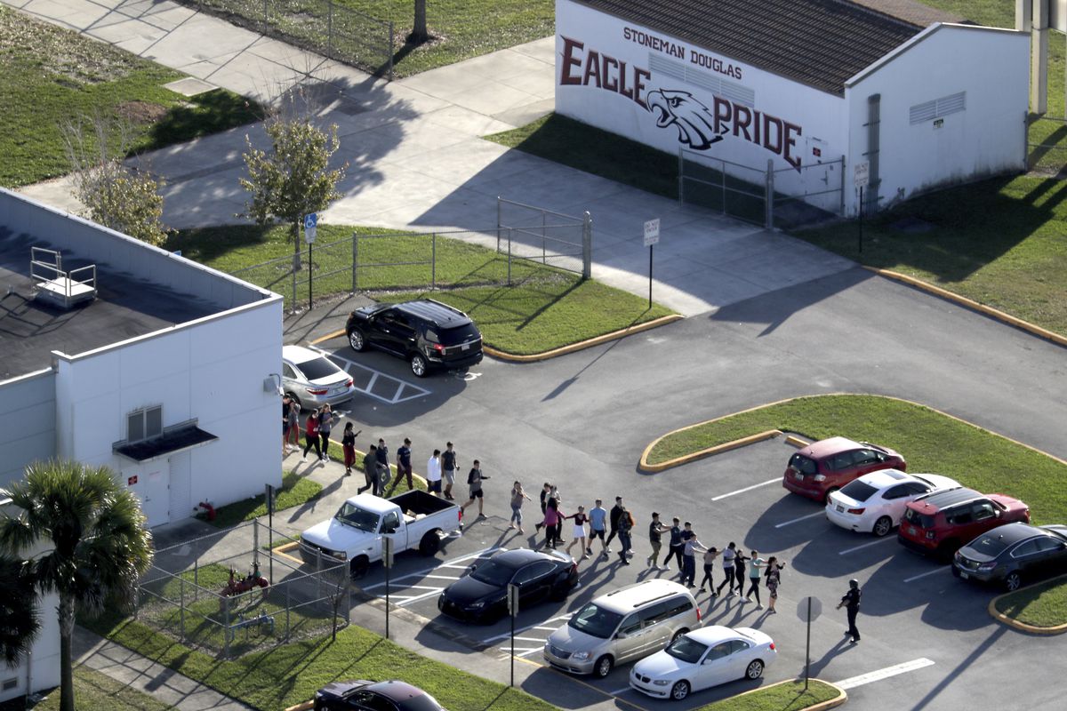 FILE - This Feb. 14, 2018 file photo shows students being evacuated by police from Marjory Stoneman Douglas High School in Parkland, Fla., after a former student opened fire on the campus.