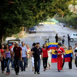 Venezuelans carrying their nation's flag walk to their consulate to vote in their country's presidential election in Havana, Cuba, Sunday, April 14, 2013. Interim President Nicolas Maduro, who served as late President Hugo Chavez's foreign minister and vice president, is running against opposition candidate Henrique Capriles. 