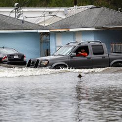 A motorist drives through flood waters in Hammond, La., Friday, March 11, 2016. Torrential rains pounded northern Louisiana for fourth day Friday, trapping several hundred people in their homes, leaving scores of roads impassable and causing widespread flooding.