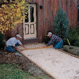 <p>DRAG A screed across the 2x4 frame to level out the sand and create a 2-in.-deep recess for the patio panels.</p>