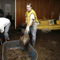 Mark Herrick, 30, right, and Gary Scott, 53, part of a local Mormon Church group, work to remove mud from the home of Pat Anderson in La Canada Flintridge.