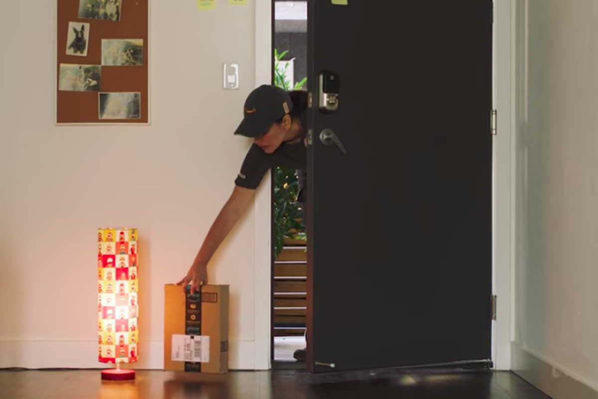 A delivery person drops off an Amazon package inside the home of a Prime member.