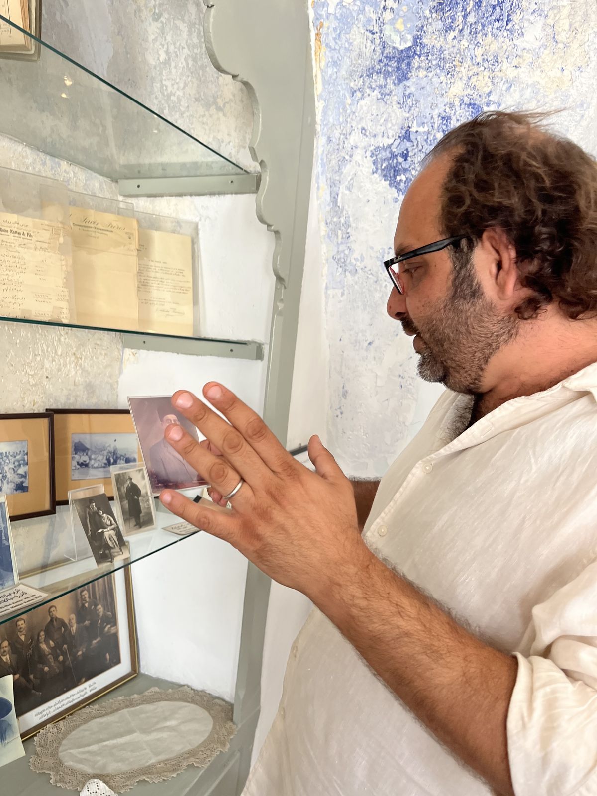 A man discussing his family history at the Bethlehem Museum&nbsp;in front of photographs