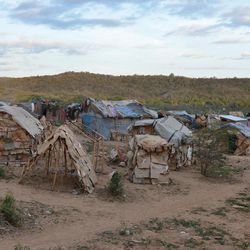 In this March 21, 2015 photo, makeshift tents of flattened cardboard boxes, bedsheets and sticks stand at a borderland encampment outside the southeast Haitian town of Anse-a-Pitres. The encampment is filled with people who either fled or were forcibly removed from the neighboring Dominican Republic amid an immigration crackdown. Within a month, authorities hope to move nearly 2,400 people in a half-dozen encampments by providing enough money for them to rent homes for a year in nearby towns. 