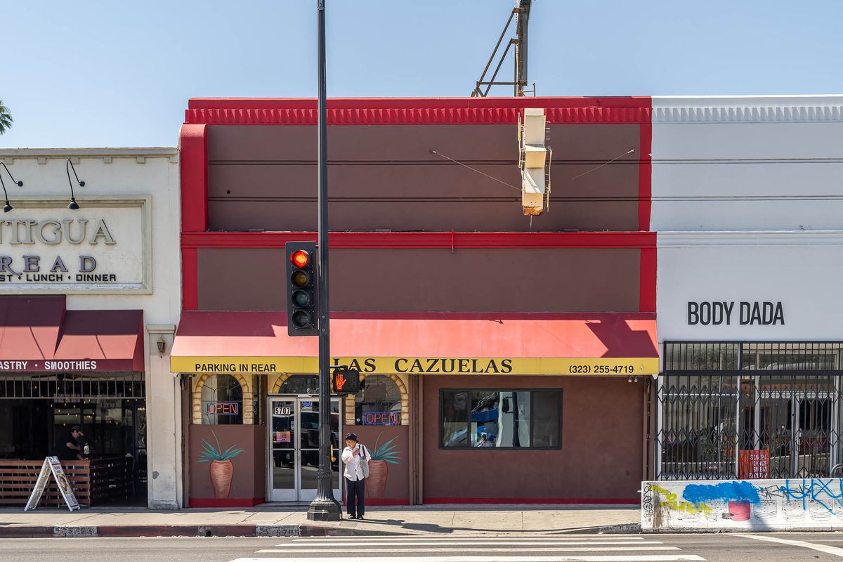 A red awning and yellow signage outside Las Cazuelas.