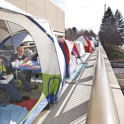 BYU student Megan Wakefield and brother Steve Wakefield, who attends UVU, eat lunch in a tent near the Marriott Center, waiting for the chance to buy basketball tickets. 