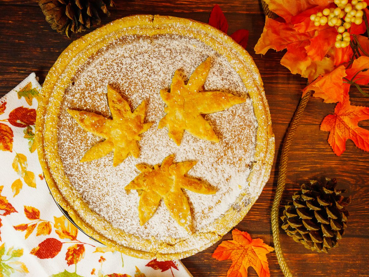 A Wild pie topped with powdered sugar and three leaves made out of pie crust.