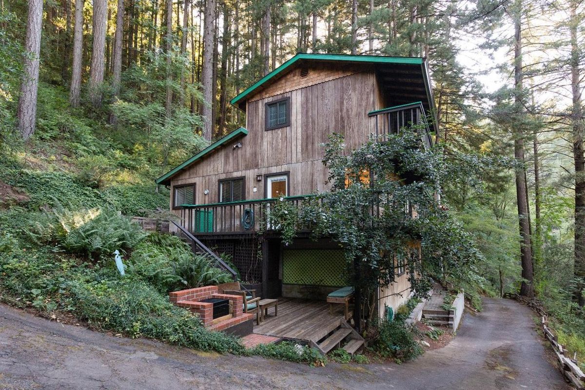 A country house on stilts surrounded by redwoods.