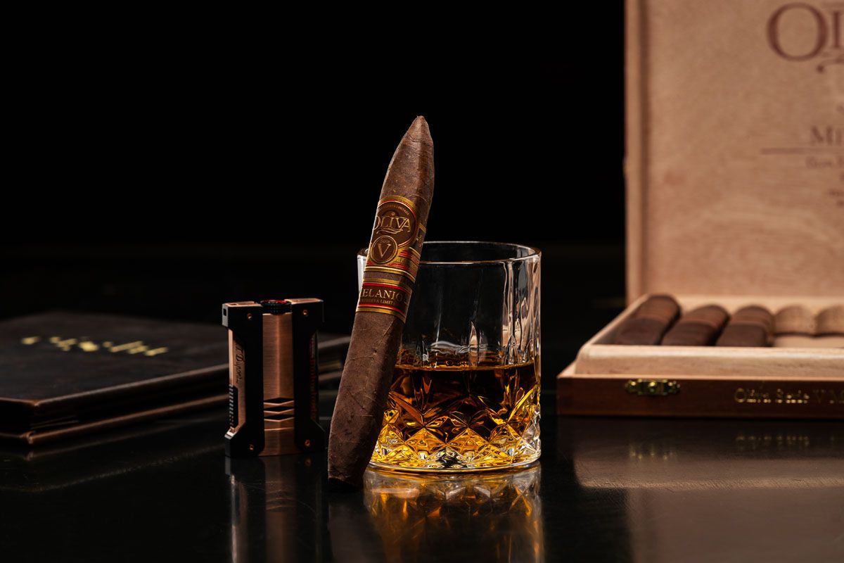 Photo of a dark liquor drink and a cigar