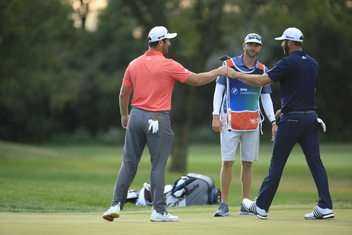 Jon Rahm of Spain and Dustin Johnson of the United States fist bump after Jon Rahm of Spain made a 66-foot putt on their first sudden-death playoff hole to win during the final round of the BMW Championship on the North Course at Olympia Fields Country Club on August 30, 2020 in Olympia Fields, Illinois.