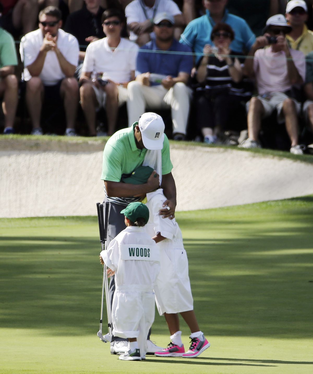 Tiger Woods hugs his daughter Sam while son Charlie watches during the par 3 contest ahead of the Masters golf tournament Wednesday, April 8, 2015, in Augusta, Ga.