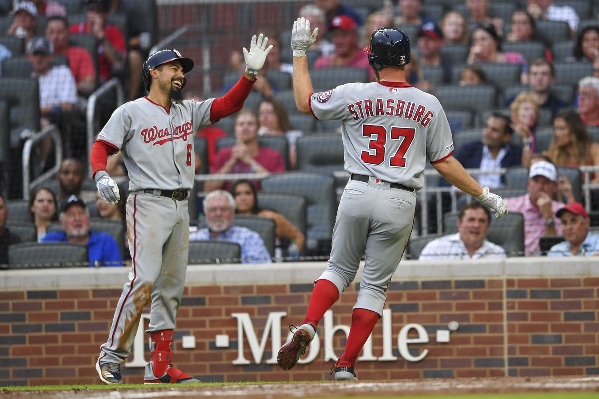 Washington Nationals starting pitcher Stephen Strasburg reacts with third baseman Anthony Rendon after scoring against the Atlanta Braves during the third inning at SunTrust Park.