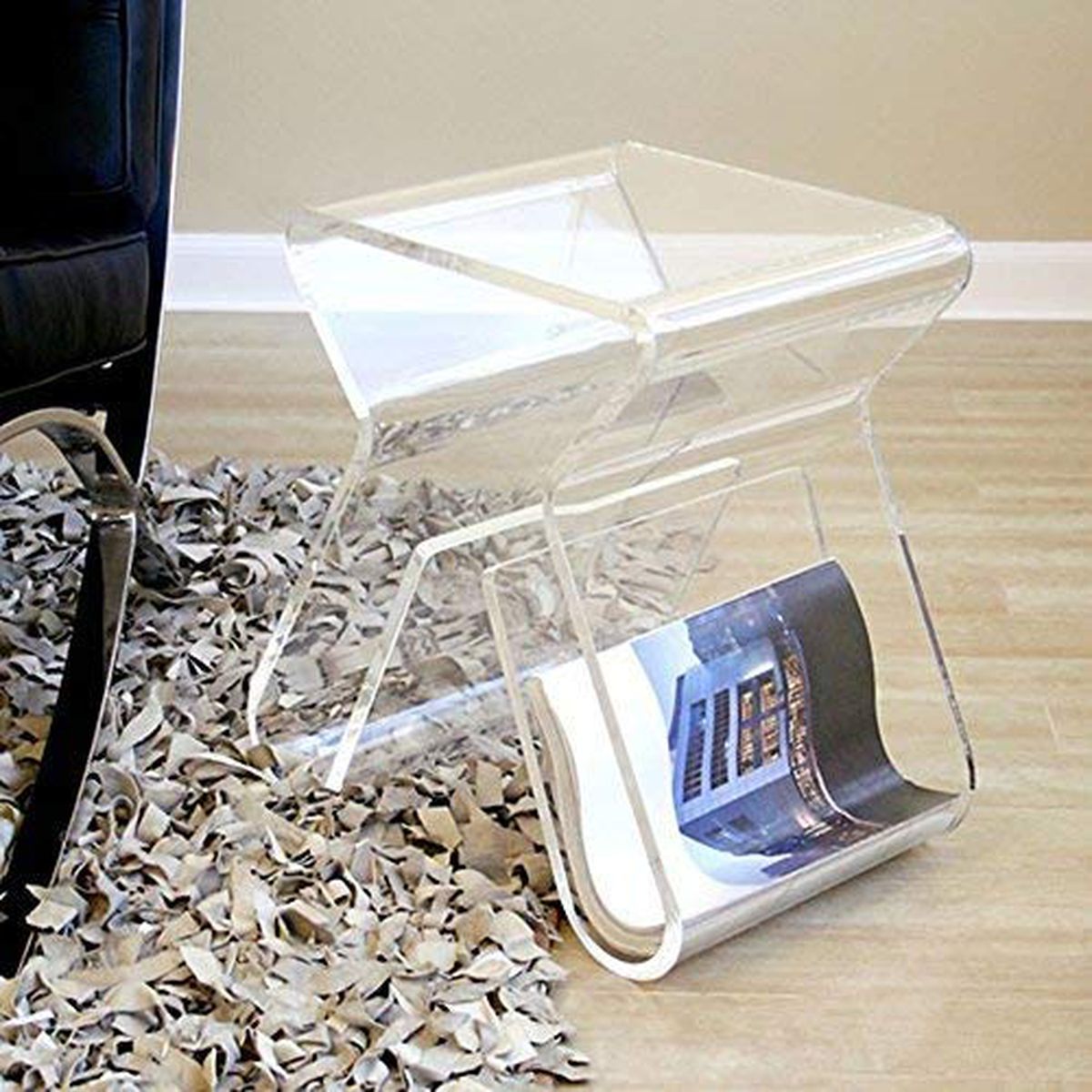 An acrylic see-through side table has space for magazines in the bottom and a compact table on top. 