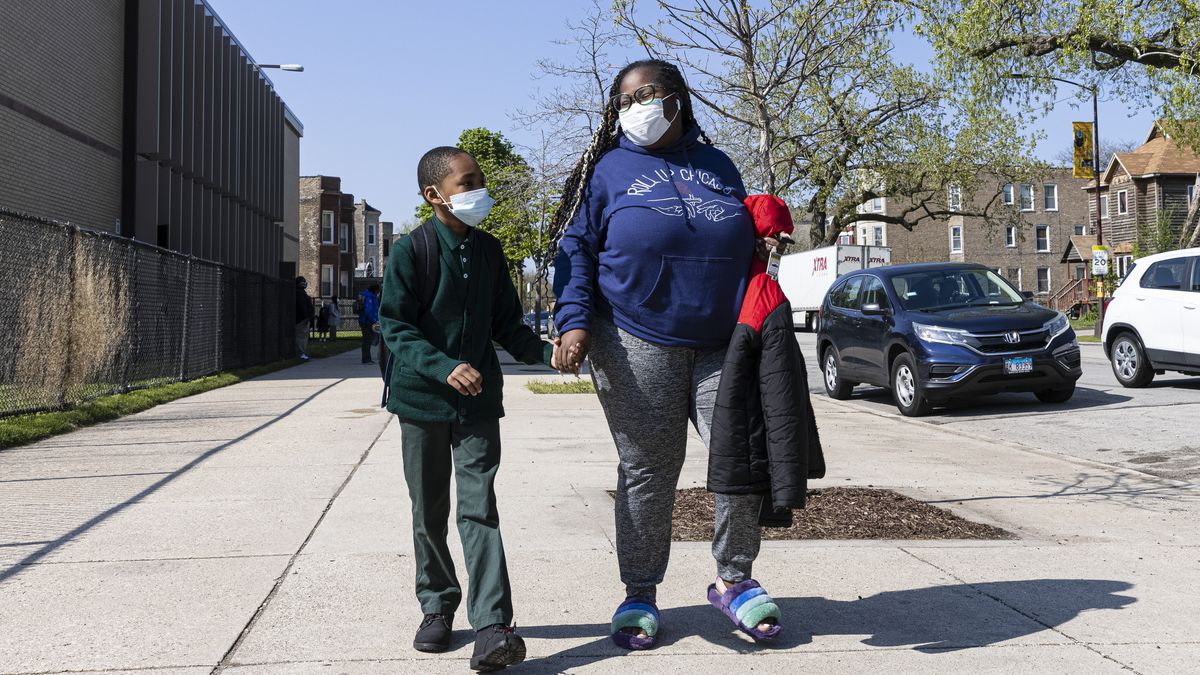 Alanna Barber and her son Sean Smith, 8, walk back to their vehicle after school outside of Beasley Elementary in Washington Park, Thursday, April 29, 2021.