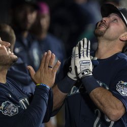 Seattle Mariners catcher Cal Raleigh (29), right, celebrates in the dugout with third baseman Eugenio Suarez (28) after hitting a solo home run during the second inning against the Milwaukee Brewers at T-Mobile Park