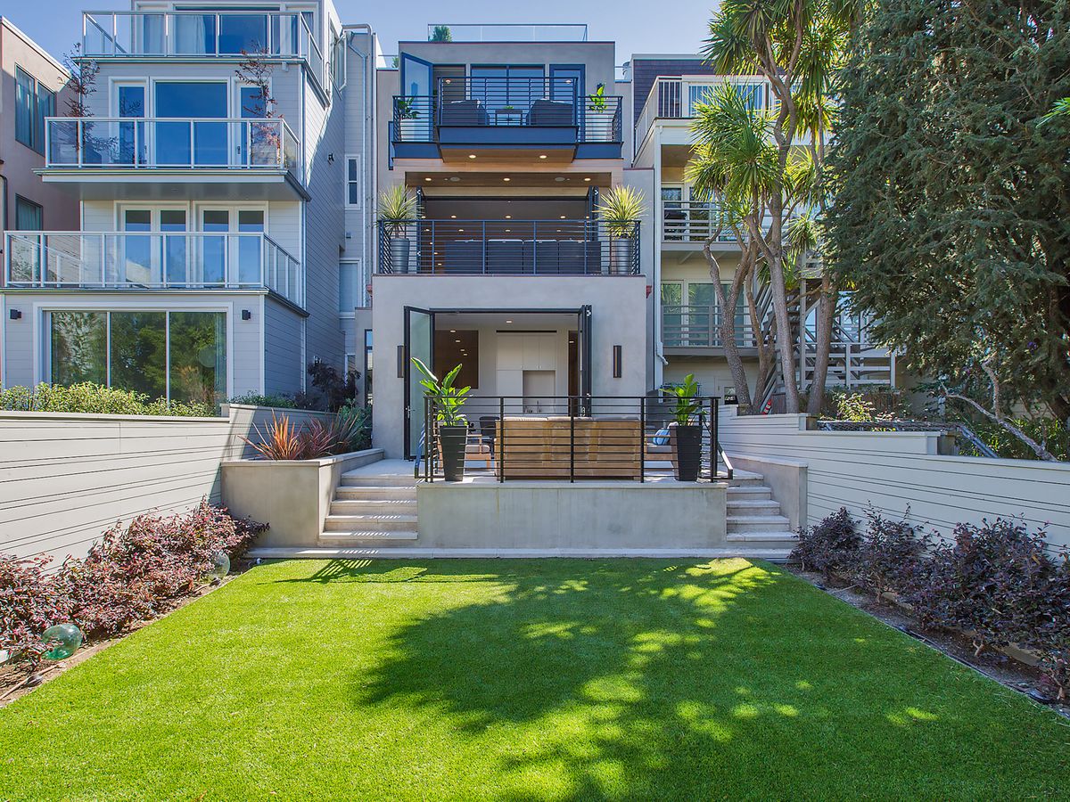 A San Francisco house with a backyard that has a green lawn.