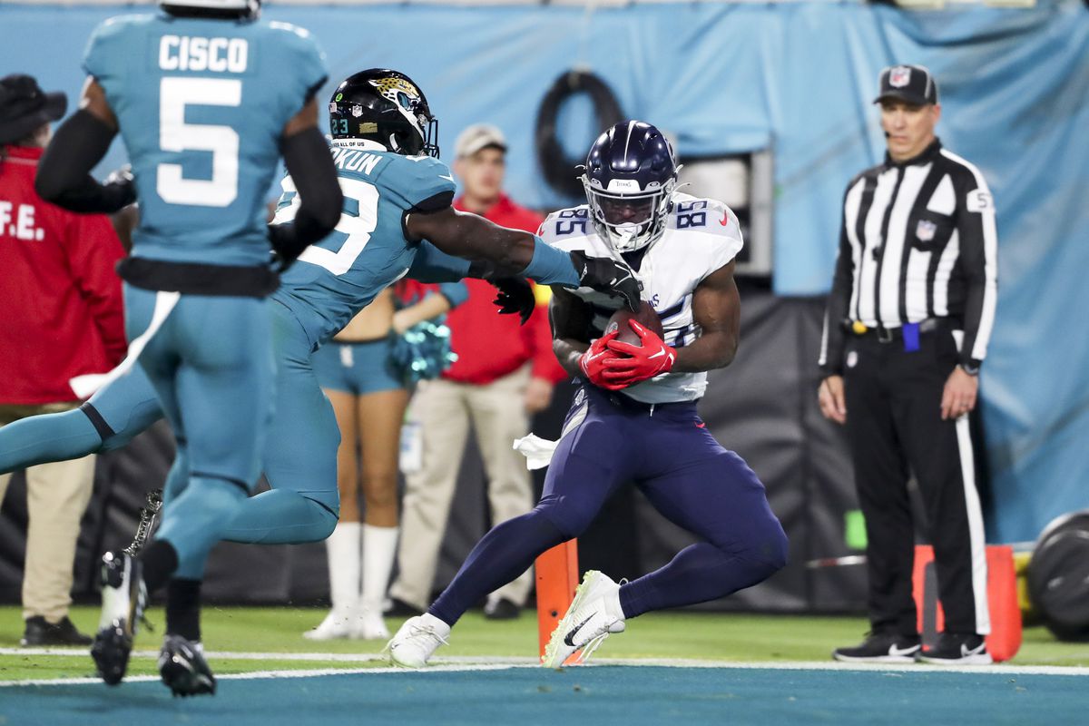 Chigoziem Okonkwo #85 of the Tennessee Titans catches a touchdown pass over Foyesade Oluokun #23 of the Jacksonville Jaguars during the second quarter at TIAA Bank Field