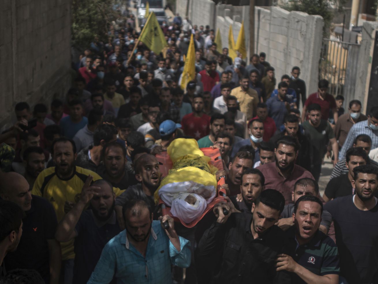 Palestinian mourners carry the body of 11-year-old Hussain Hamad, who was killed by an explosion during the ongoing conflict between Israel and Hamas, during his funeral in Beit Hanoun, northern Gaza Strip, Tuesday, May 11, 2021.