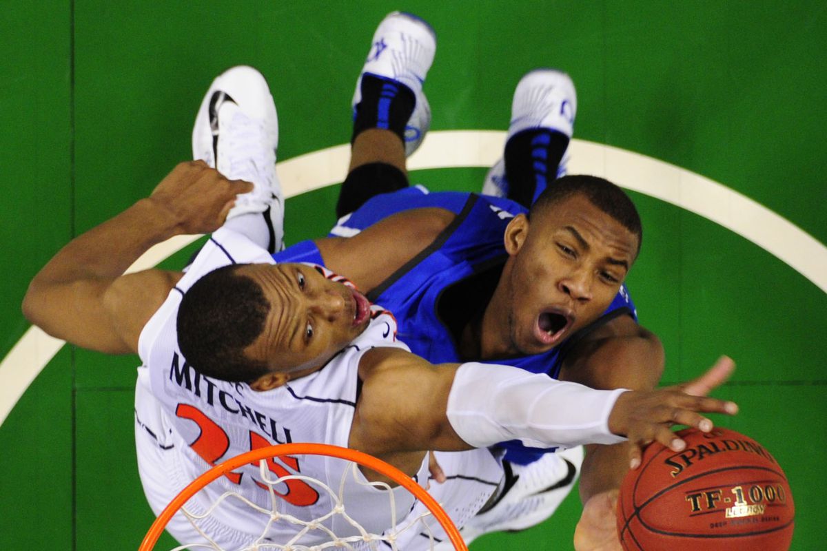 Mar 16, 2014; Greensboro, NC, USA; Duke Blue Devils guard Rasheed Sulaimon (14) shoots as Virginia Cavaliers forward Akil Mitchell (25) defends. The Cavilers defeated the Blue Devils 72-63 in the championship game of the ACC college basketball tourna