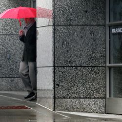 A man with an umbrella steps out into the rain in Salt Lake City on Monday, March 14, 2016.