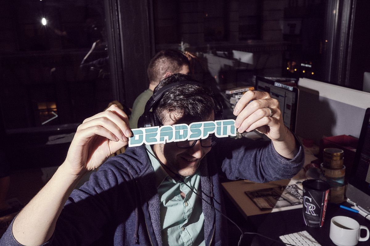 An employee of the website Deadspin holds the logo in front of his face at the company’s office in Manhattan, New York on November 1, 2018.