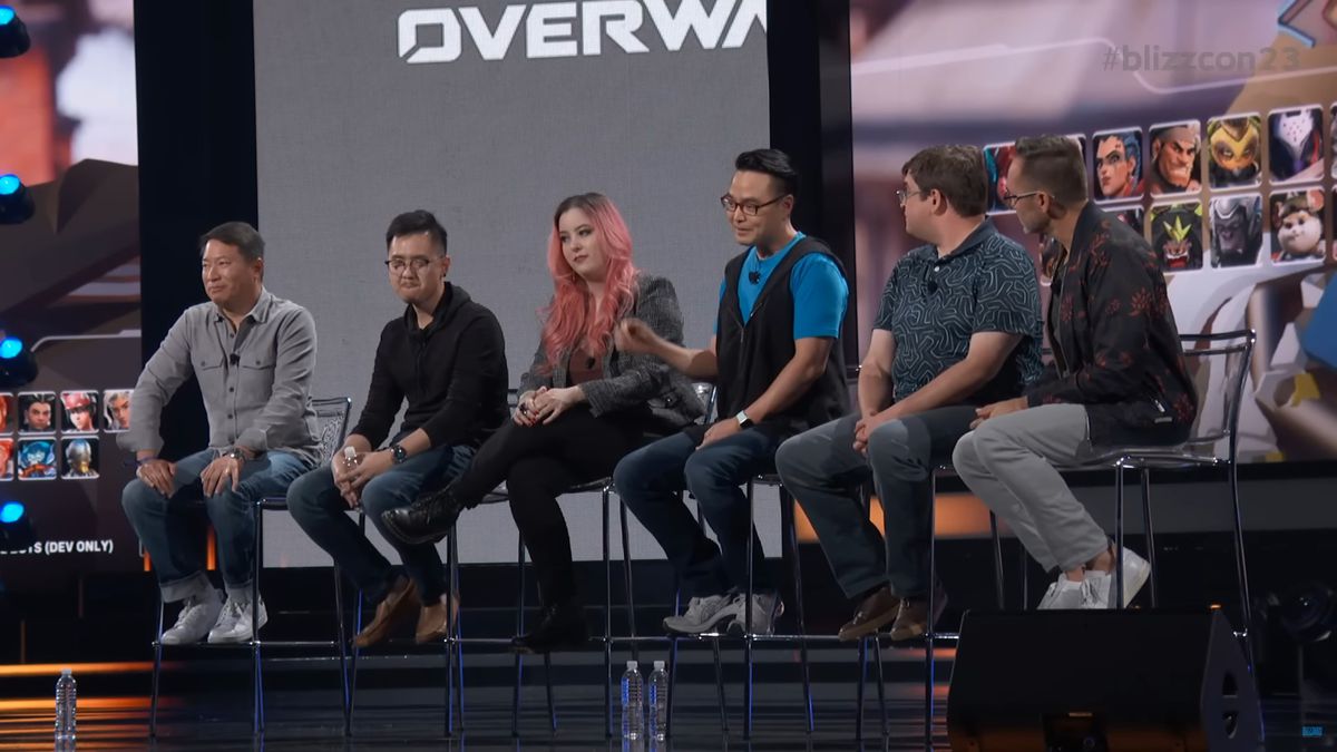 A still of the Overwatch 2 - What’s Next panel from BlizzCon 2023, showing the development team in front of a game screenshot that teases the 10th tank hero
