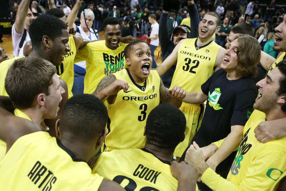 Oregon's Joseph Young, center, leads the Ducks in a cheer after defeating BYU in overtime 100-96 in an NCAA college basketball game in Eugene on Saturday, Dec. 21, 2013. (AP Photo/Chris Pietsch)
