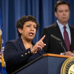 Attorney General Loretta Lynch, accompanied by FBI Director James Comey, speaks during a news conference at the Justice Department in Washington, Thursday, March 24, 2016. Seven hackers tied to the Iranian government were charged Thursday in a series of punishing cyberattacks on a small dam outside New York City and on dozens of banks _ intrusions that reached into American infrastructure and disrupted the financial system, U.S. law enforcement officials said. 