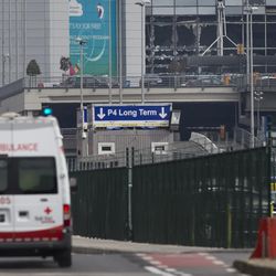 An ambulance heads to Zaventem airport as the blown out windows are seen top right in Brussels, Belgium, Tuesday, March 22, 2016. Authorities in Europe have tightened security at airports, on subways, at the borders and on city streets after deadly attacks Tuesday on the Brussels airport and its subway system. 