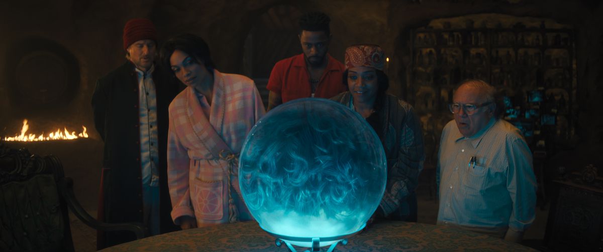 Owen Wilson, Rosario Dawson, LaKeith Stanfield, Tiffany Haddish, and Danny DeVito ogle a large crystal ball