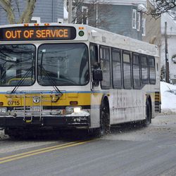 An out-of-service transit bus rolls through Somerville, Mass.,Tuesday, Feb. 10, 2015. The storm left the Boston-area with another two feet of snow and forced the MBTA to buses on a limited basis, and suspended all rail service for the day Tuesday to clean tracks and repair equipment. 