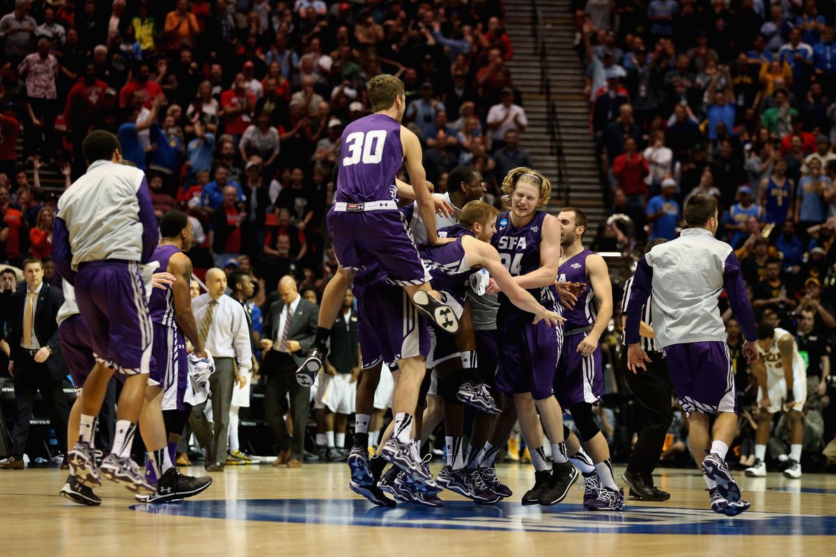SAN DIEGO, CA - MARCH 21: Jacob Parker #34, Thomas Walkup #0 and Tanner Clayton #30 of the Stephen F. Austin Lumberjacks celebrate with teammates after winning the game 77-75 in overtime against the Virginia Commonwealth Rams during the second round 