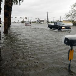 A drives moves through flood waters left behind by Hurricane Harvey, Saturday, Aug. 26, 2017, in Aransas Pass, Texas. Harvey rolled over the Texas Gulf Coast on Saturday, smashing homes and businesses and lashing the shore with wind and rain so intense that drivers were forced off the road because they could not see in front of them.