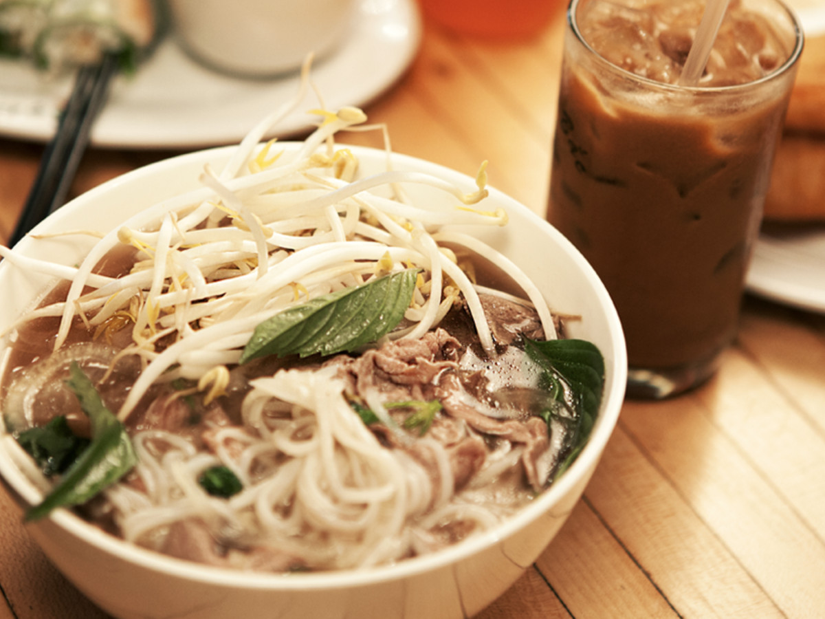 A bowl of pho at Pho Bac Sup Shop with iced coffee on the side.
