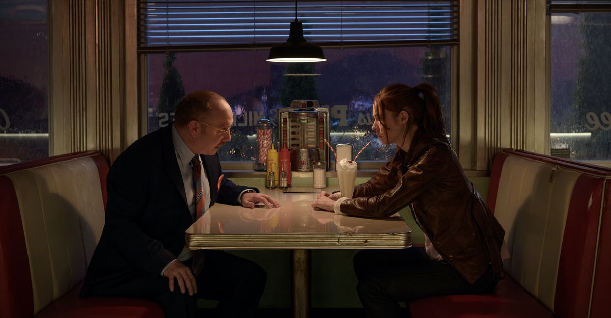 Paul Giamatti sits opposite Karen Gillan in a nighttime diner scene from Gunpowder Milkshake