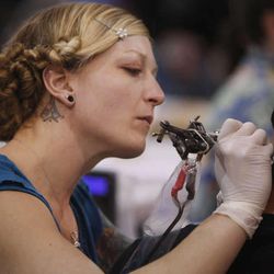 Tattoo artist Miss Amanda works on Chris Speaks at the Salt Lake City International Tattoo Convention  in Salt Lake City, Utah, Friday, Feb. 18, 2011. A bill that would prohibit tattooing minors, even with parental permission, was placed on hold by the House Judiciary Committee for possible amendments and to allow the sponsor more time to obtain information about other states' laws.