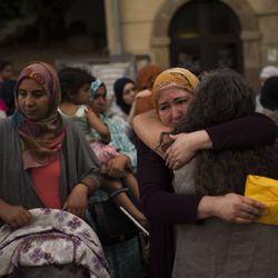 Members of the local Muslim community gather along with relatives of young men believed responsible for the attacks in Barcelona and Cambrils to denounce terrorism and show their grief in Ripoll, north of Barcelona, Spain, Sunday Aug. 20, 2017. Yellow sheets reading Catalan: "Peace". (AP Photo/Francisco Seco)