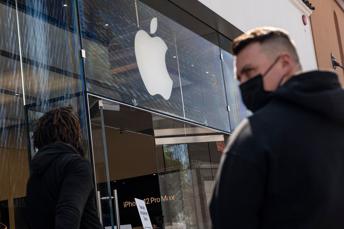 A man wearing a face mask is seen outside an Apple retail store