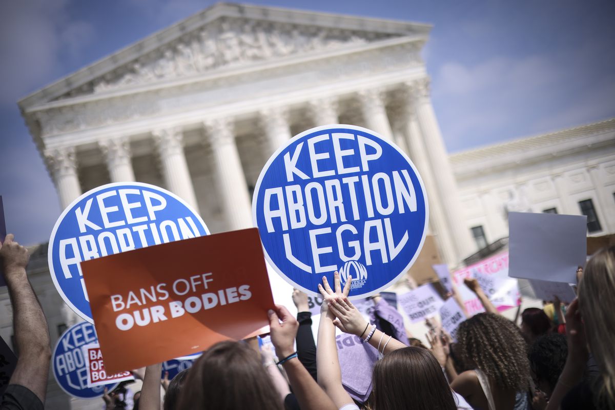 Protesters in front of the Supreme Court building hold signs that read “Bans off our bodies” and “Keep abortion legal.”