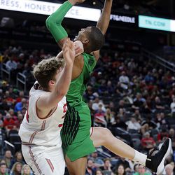 Utah Utes forward Jayce Johnson gets tangled up with Oregon Ducks forward Kenny Wooten after Johnson attempts a shot during the Pac-12 basketball tournament in Las Vegas on Thursday, March 8, 2018.
