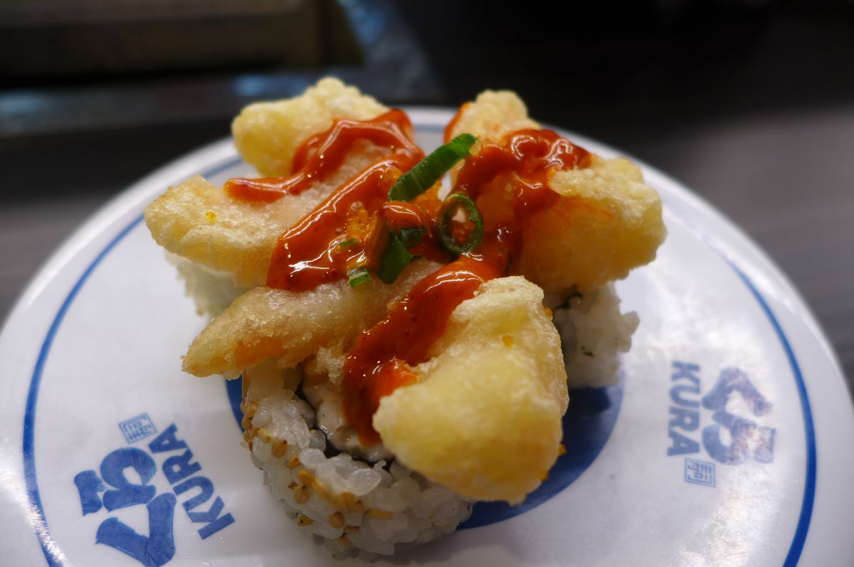 Three fried shrimp on top of cut nori rolls.